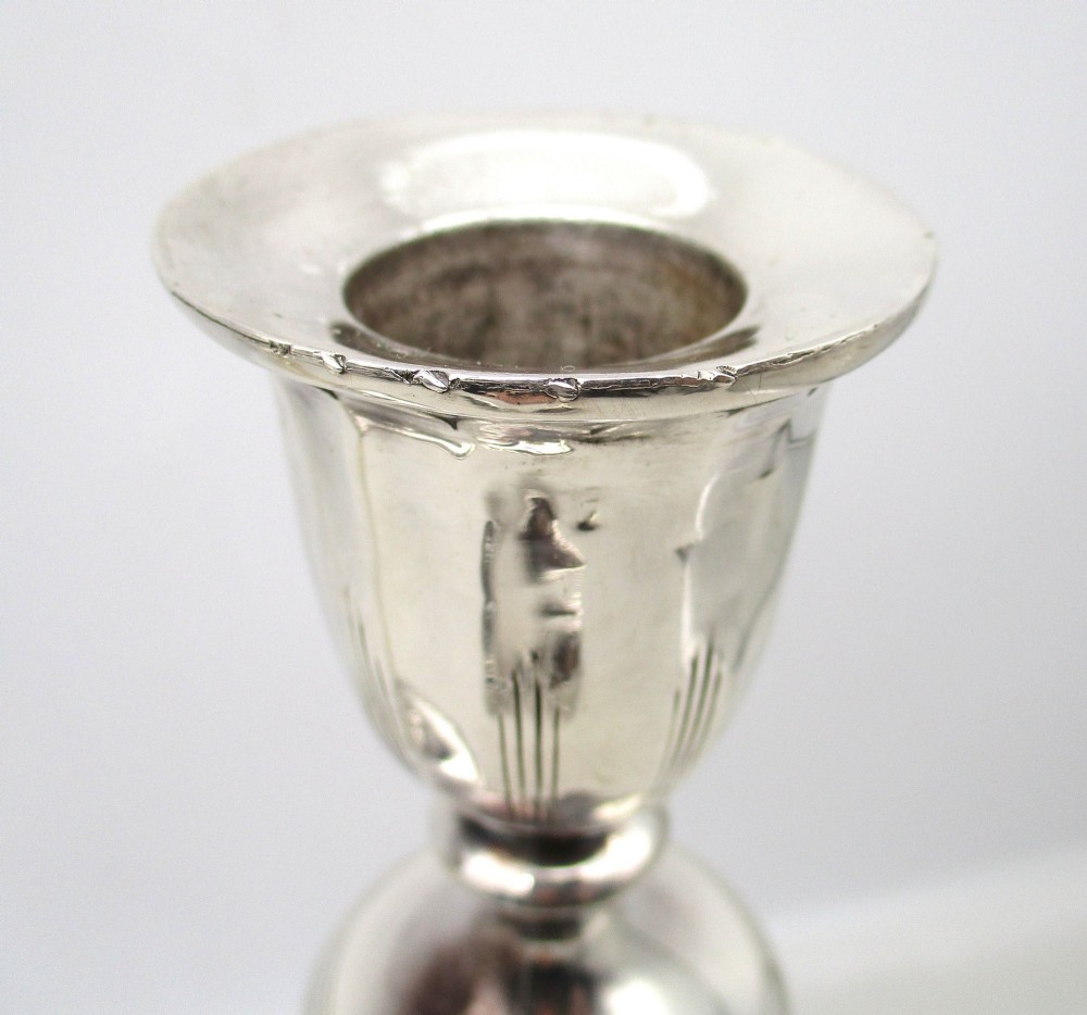 A pair of 19th-century silver-plated candlesticks featuring fluted tapered stems, urn-form sconces, and circular stepped bases. View IV