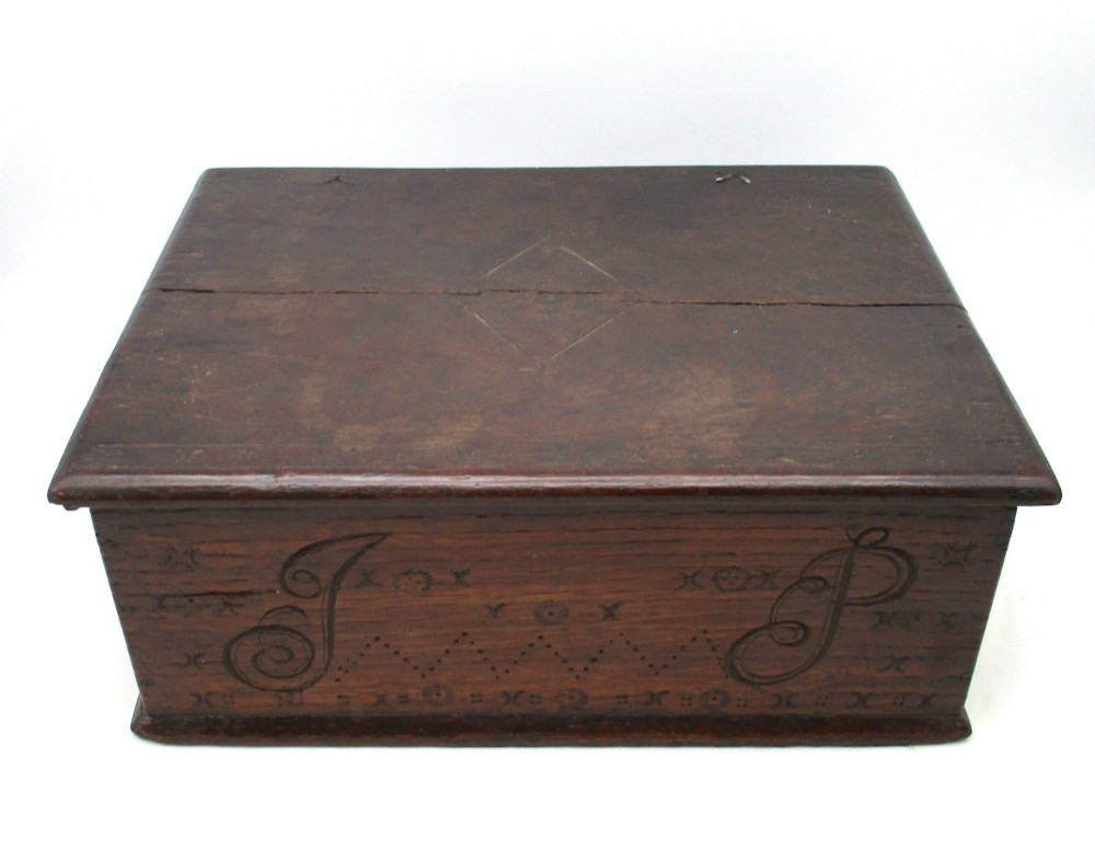 A rectangular dark oak document box featuring carved initials and geometric chip-carved detailing across the front panel. View II