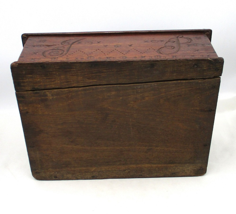 A rectangular dark oak document box featuring carved initials and geometric chip-carved detailing across the front panel. View X