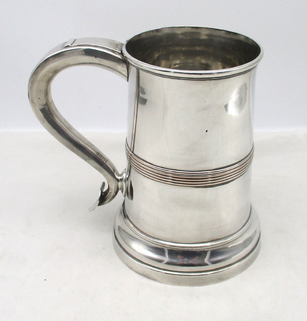 A Georgian Old Sheffield plated silver tankard featuring a reeded central band, a curved handle, and a stepped circular base. View II