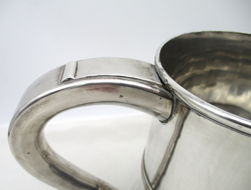 A Georgian Old Sheffield plated silver tankard featuring a reeded central band, a curved handle, and a stepped circular base. View IV
