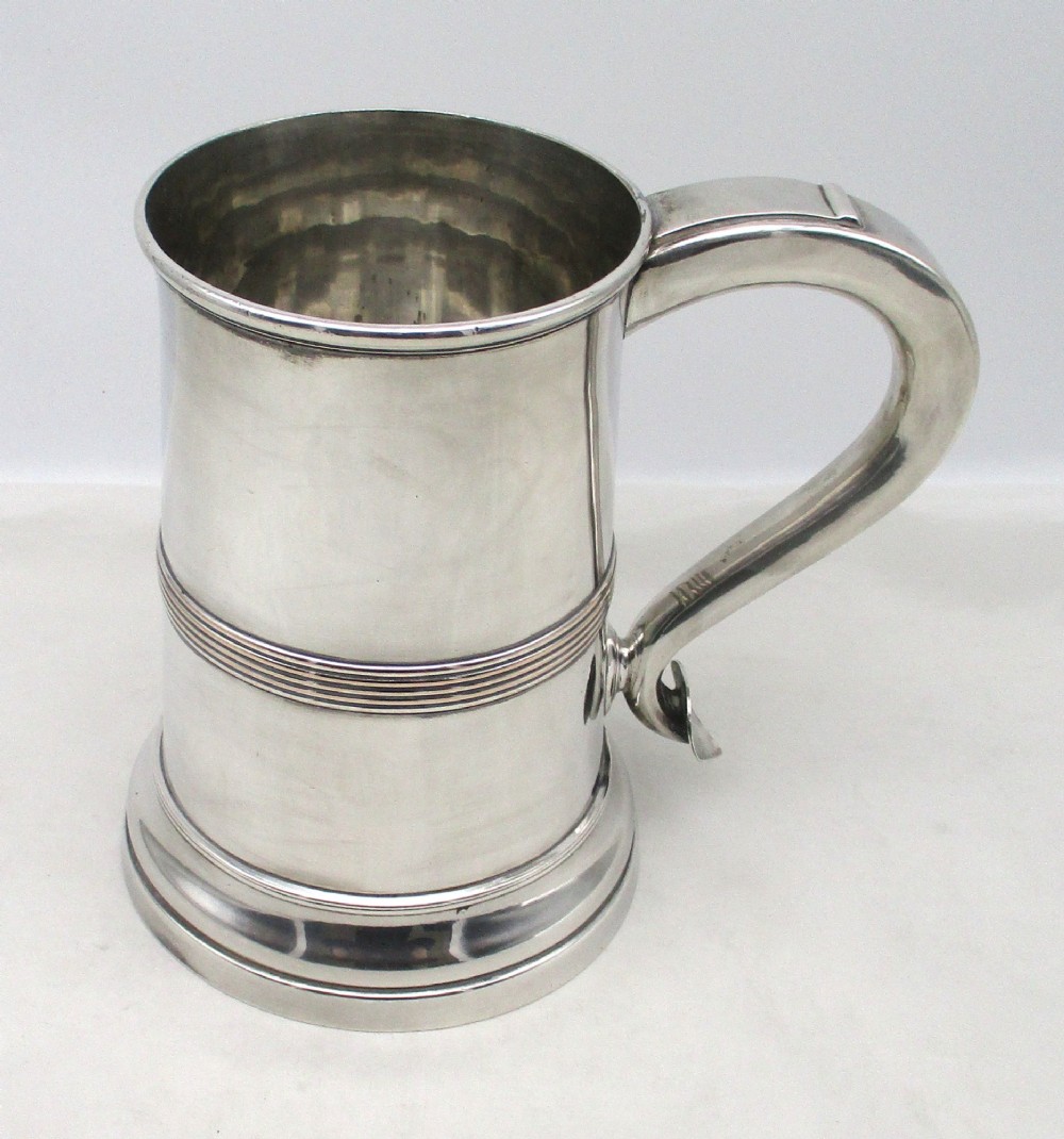 A Georgian Old Sheffield plated silver tankard featuring a reeded central band, a curved handle, and a stepped circular base. View VIII