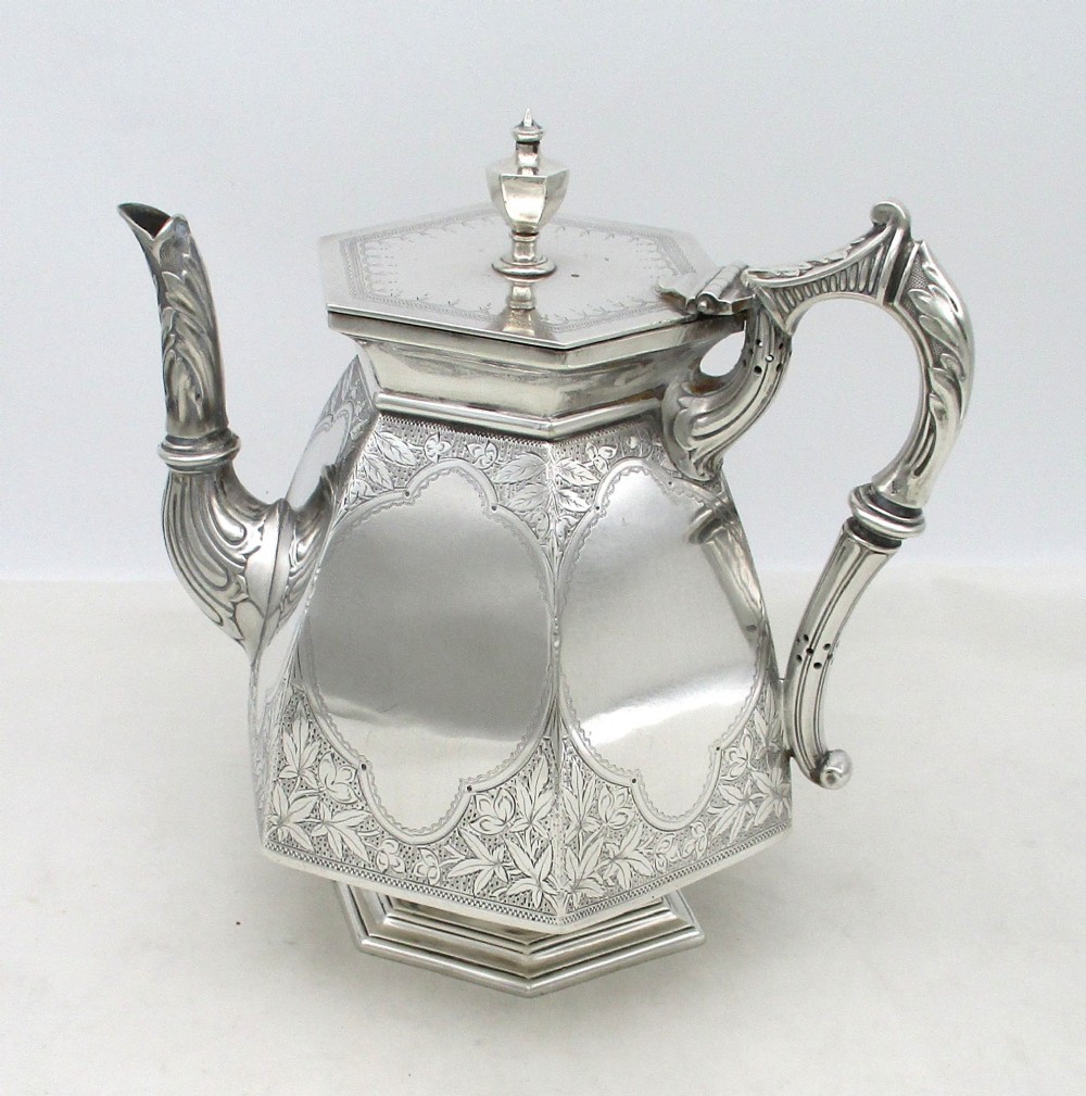 An octagonal silver plated teapot featuring floral engravings, a stylised handle with insulators, a shaped spout, and a finial lid. View II