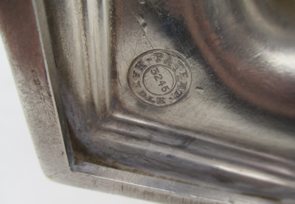 An octagonal silver plated teapot featuring floral engravings, a stylised handle with insulators, a shaped spout, and a finial lid. View XI