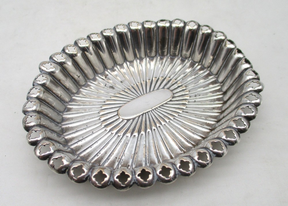 An 18th-century oval Old Sheffield Plated pin tray featuring fluted radiating panels, a smooth central oval, and a pierced scalloped rim. View II