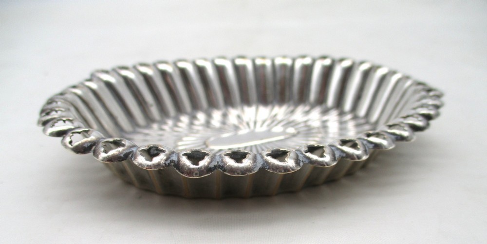 An 18th-century oval Old Sheffield Plated pin tray featuring fluted radiating panels, a smooth central oval, and a pierced scalloped rim. View III