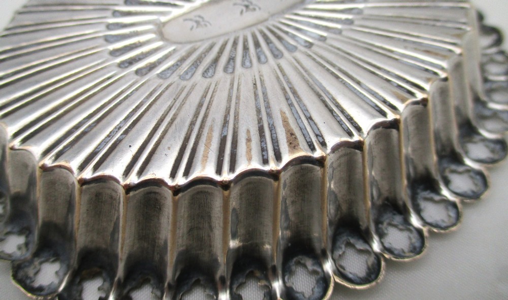 An 18th-century oval Old Sheffield Plated pin tray featuring fluted radiating panels, a smooth central oval, and a pierced scalloped rim. View VI
