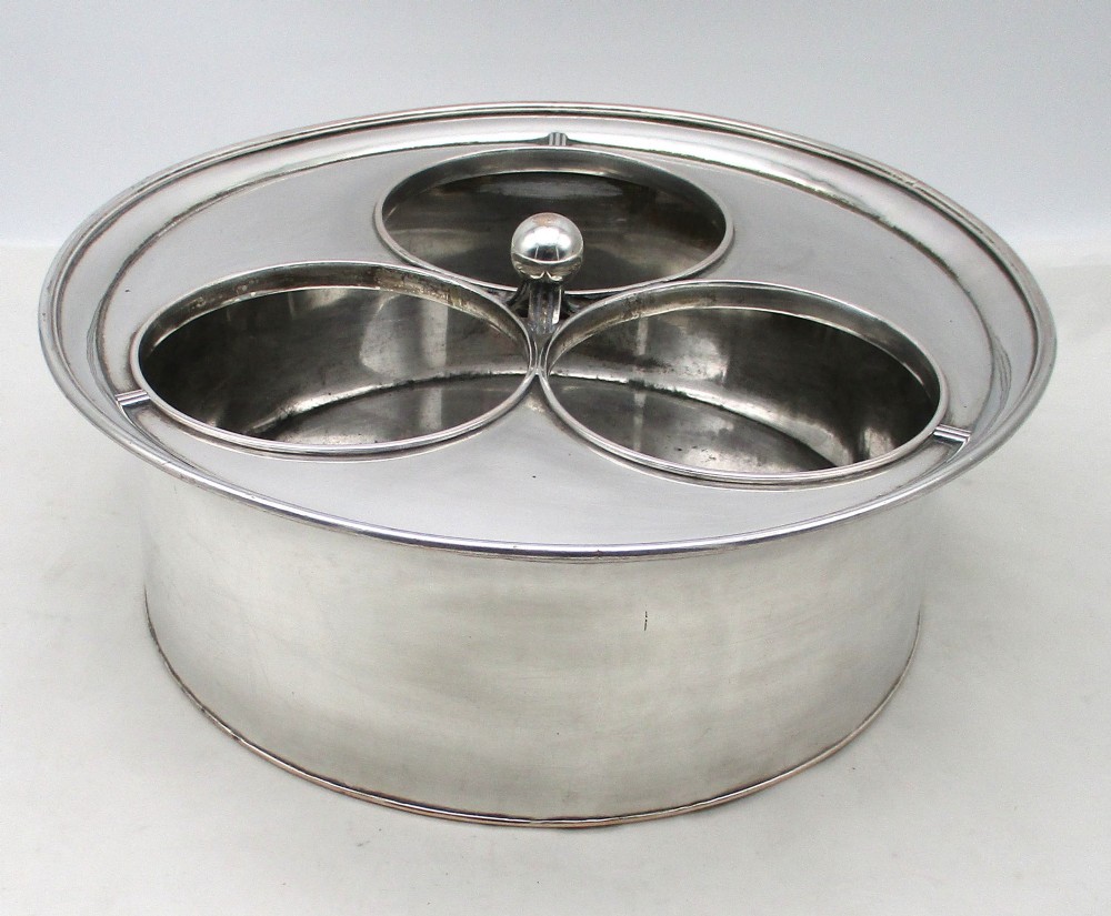 An oval Georgian silver-plated wine cooler designed to hold three bottles with a central finial handle.