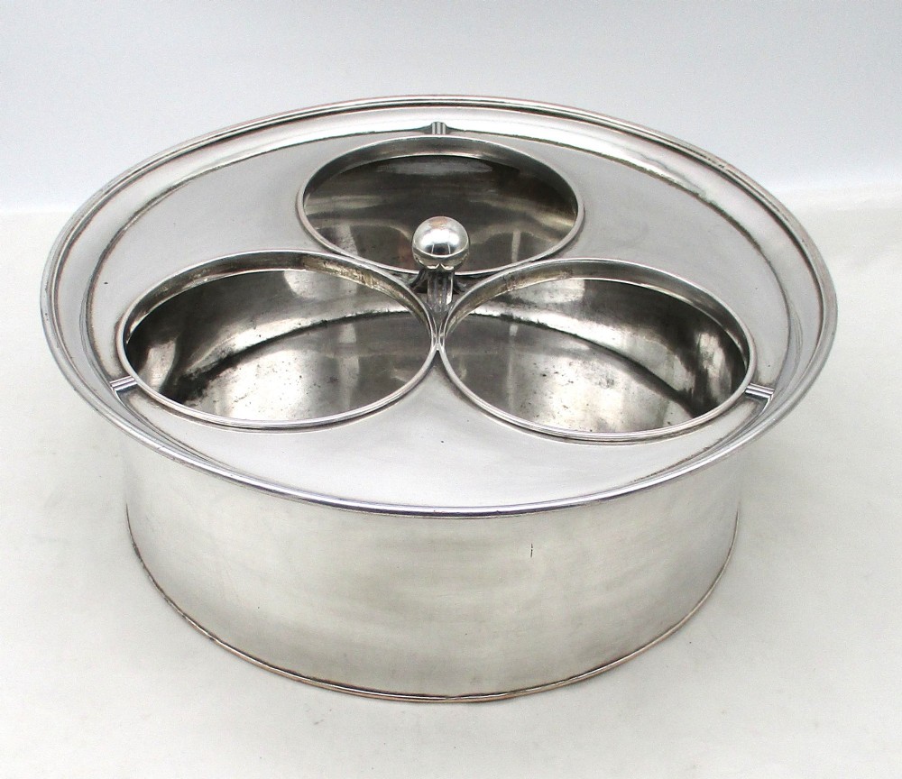 An oval Georgian silver-plated wine cooler designed to hold three bottles with a central finial handle. View II