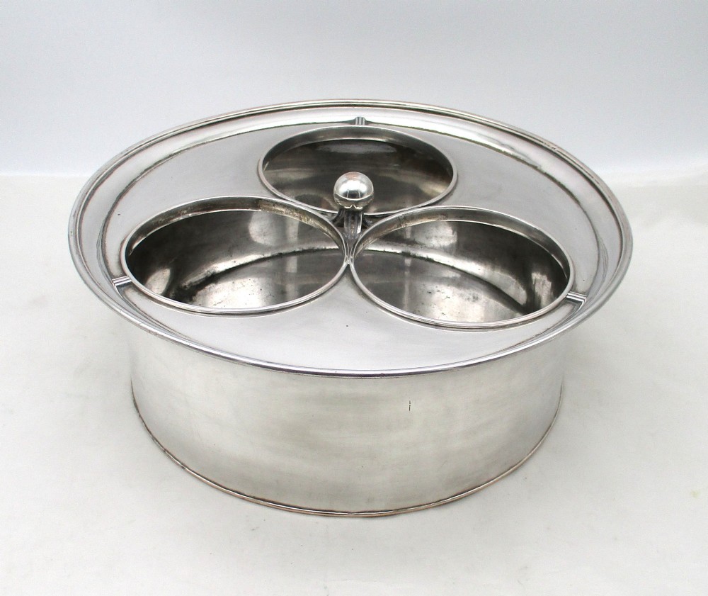 An oval Georgian silver-plated wine cooler designed to hold three bottles with a central finial handle. View III