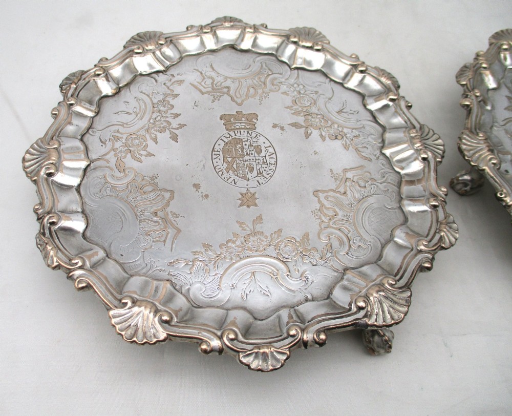 A pair of circular 18th-century Old Sheffield plated card trays with shell borders, heraldic crest engravings, and small scroll feet. View II