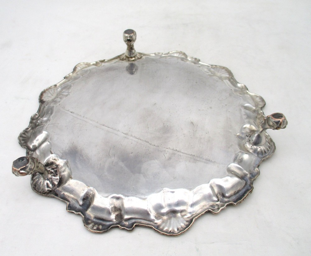 A pair of circular 18th-century Old Sheffield plated card trays with shell borders, heraldic crest engravings, and small scroll feet. View VII