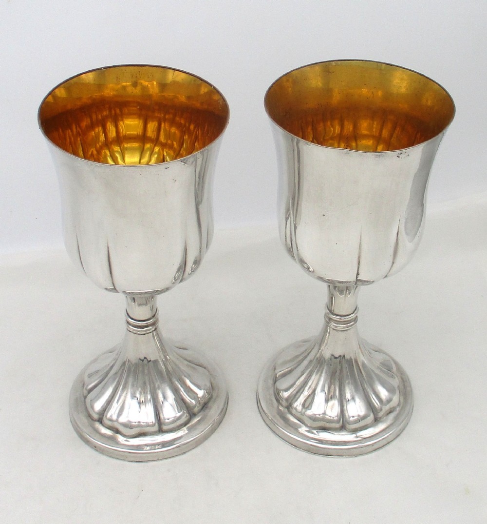 A pair of silver-plated Old Sheffield chalices featuring fluted lower bowls, raised lobed bases, and gilded interiors engraved with chapel inscriptions. View VIII