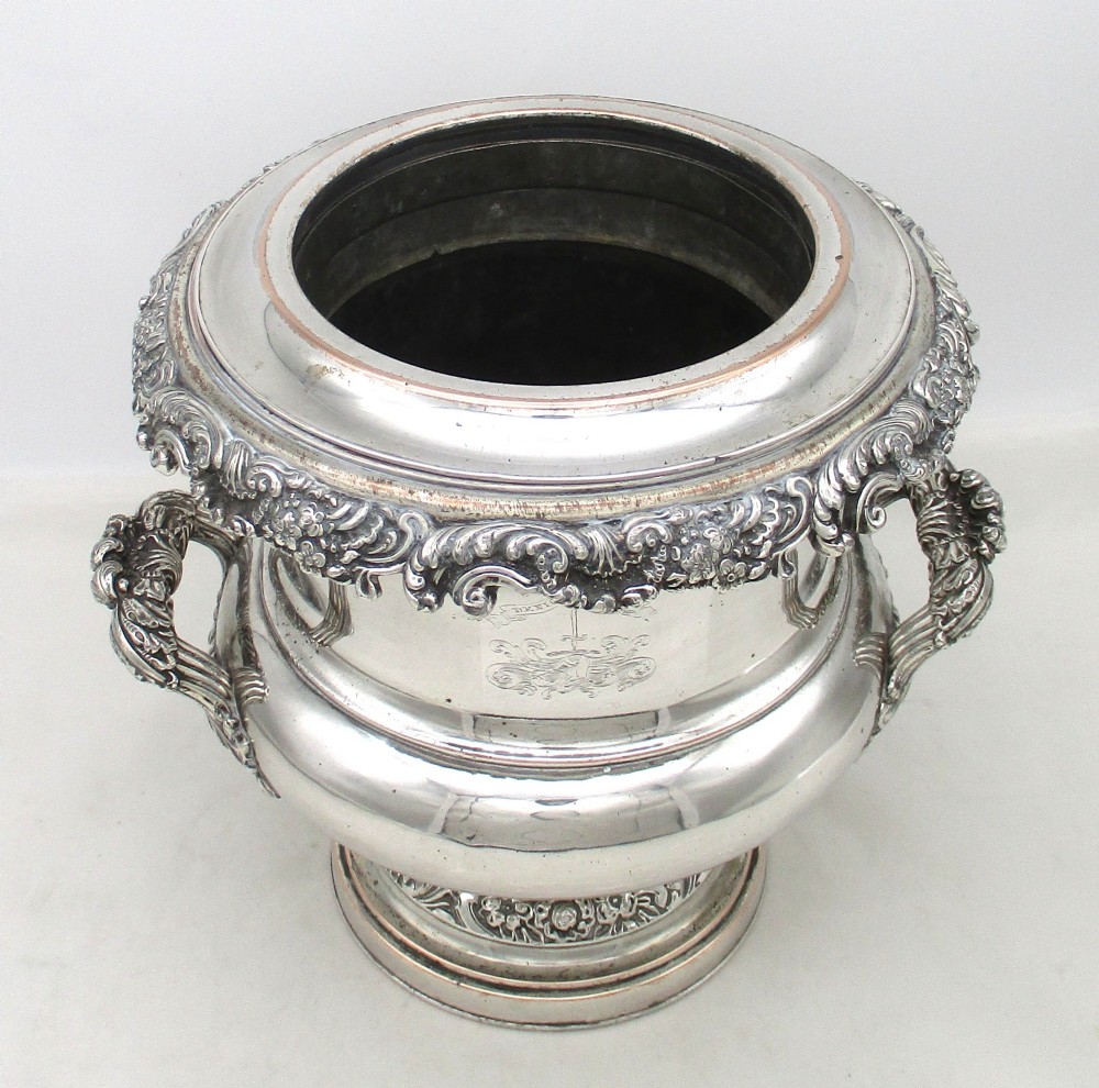 A Georgian silver-plated double-handled wine cooler featuring an engraved family crest, foliage borders, and a pedestal base. View II