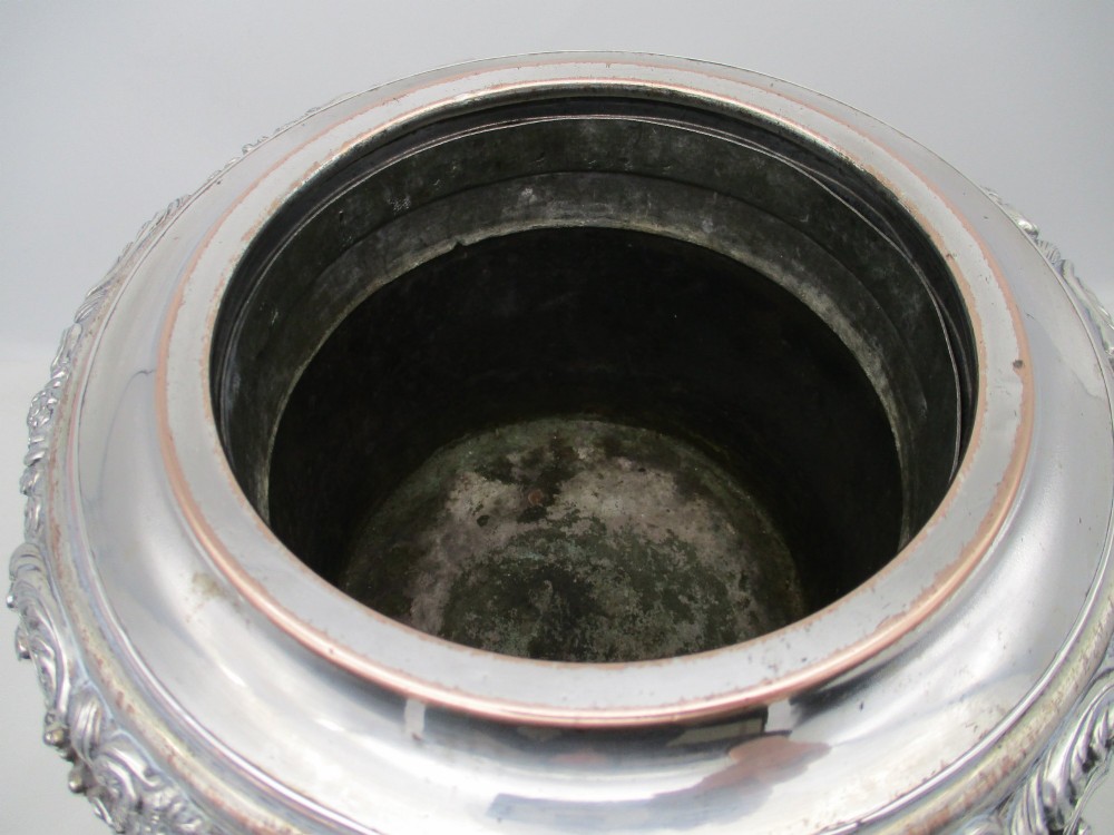 A Georgian silver-plated double-handled wine cooler featuring an engraved family crest, foliage borders, and a pedestal base. View IV