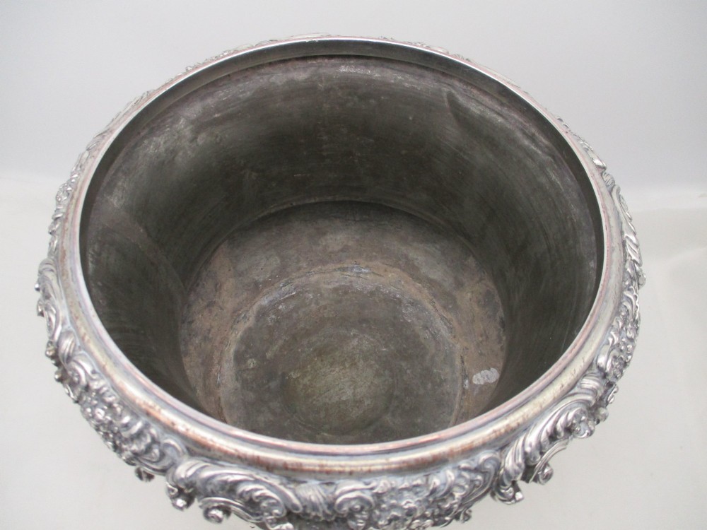 A Georgian silver-plated double-handled wine cooler featuring an engraved family crest, foliage borders, and a pedestal base. View V