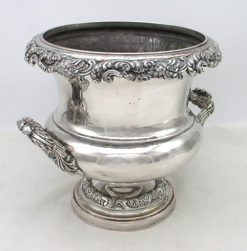 A Georgian silver-plated double-handled wine cooler featuring an engraved family crest, foliage borders, and a pedestal base. View VIII