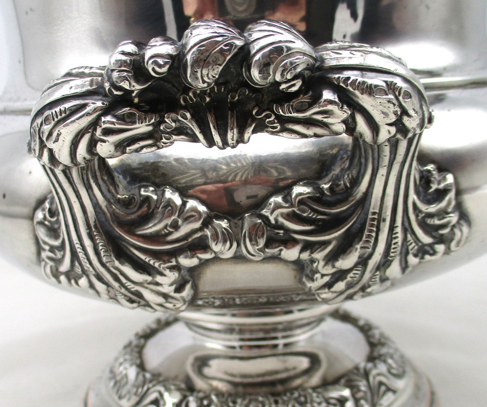 A Georgian silver-plated double-handled wine cooler featuring an engraved family crest, foliage borders, and a pedestal base. View IX