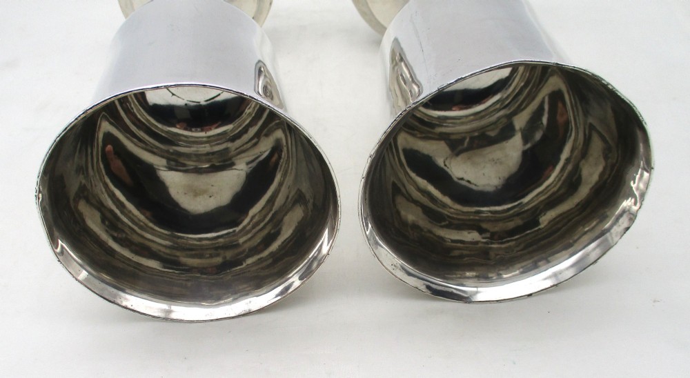 A pair of tall silver-plated church chalices featuring flared rims, knopped central stems, and stepped circular bases. View IV