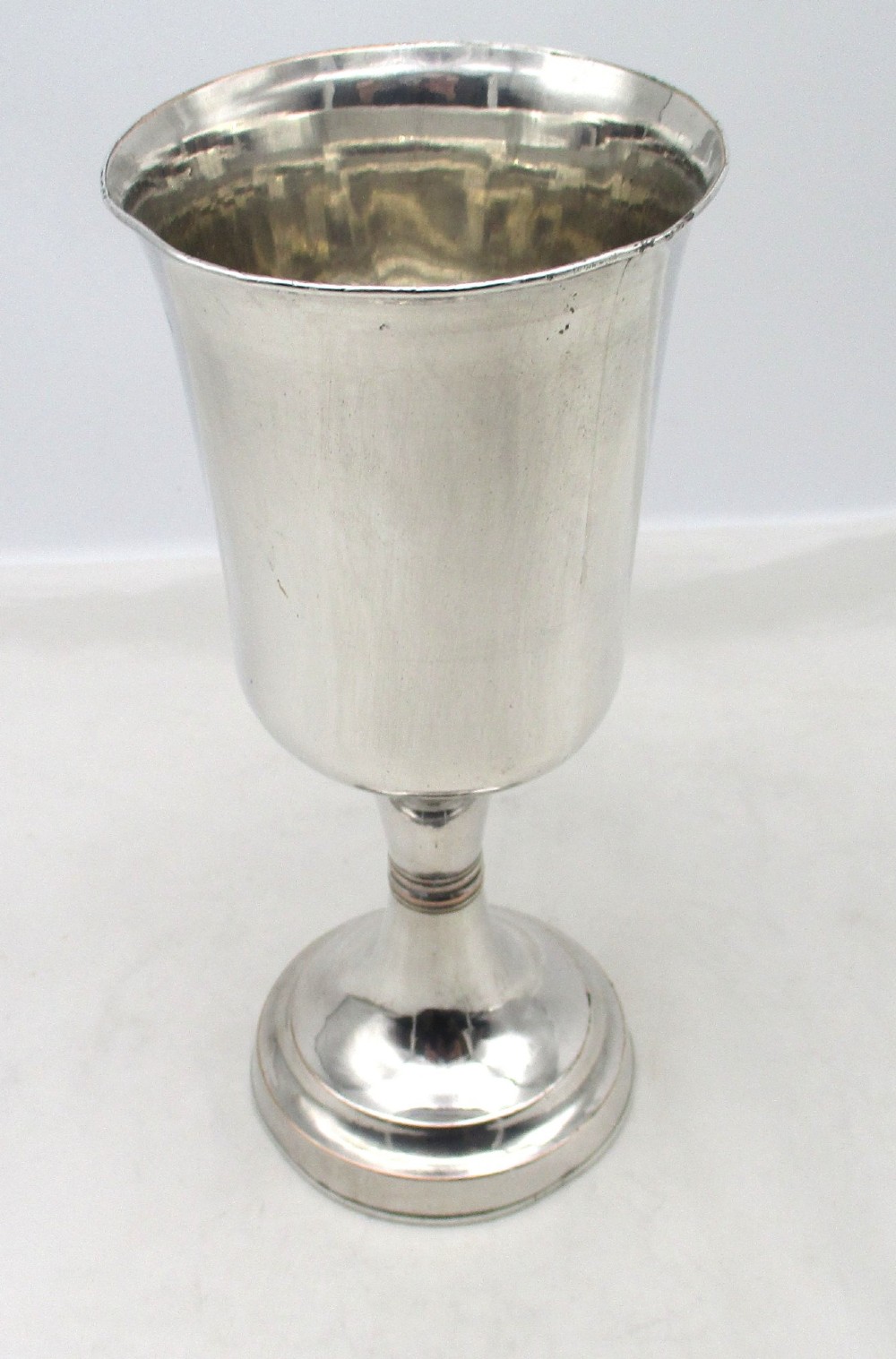 A pair of tall silver-plated church chalices featuring flared rims, knopped central stems, and stepped circular bases. View VI