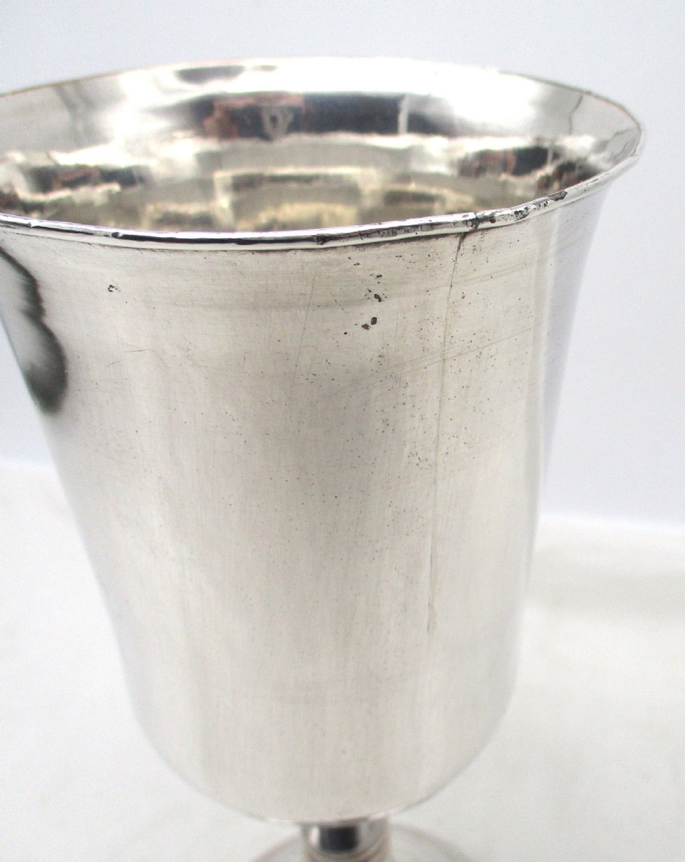 A pair of tall silver-plated church chalices featuring flared rims, knopped central stems, and stepped circular bases. View VII