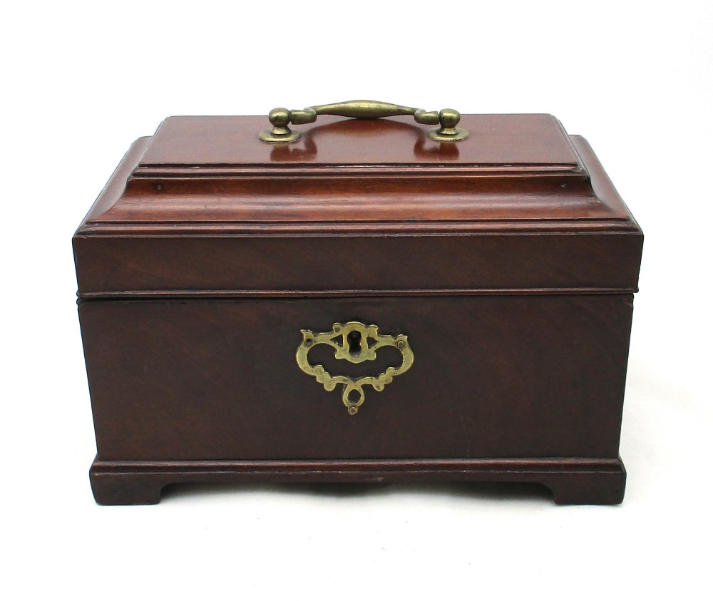 A rectangular George III mahogany tea caddy featuring a stepped hinged lid, a brass swan-neck handle, and a pierced brass keyhole escutcheon.