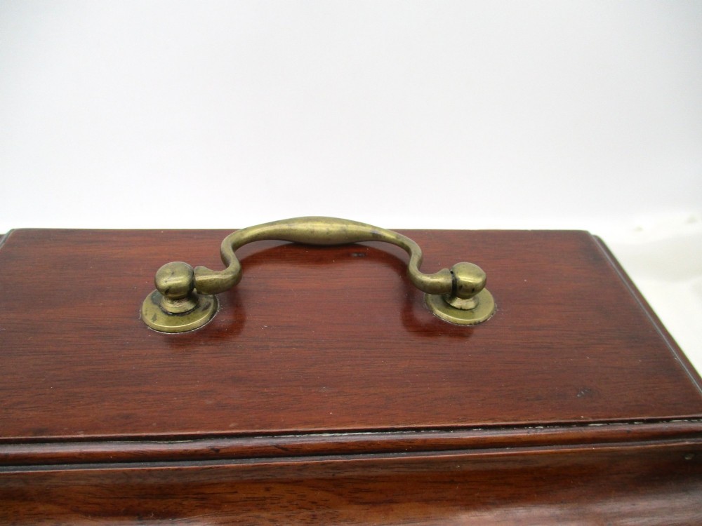 A rectangular George III mahogany tea caddy featuring a stepped hinged lid, a brass swan-neck handle, and a pierced brass keyhole escutcheon. View III