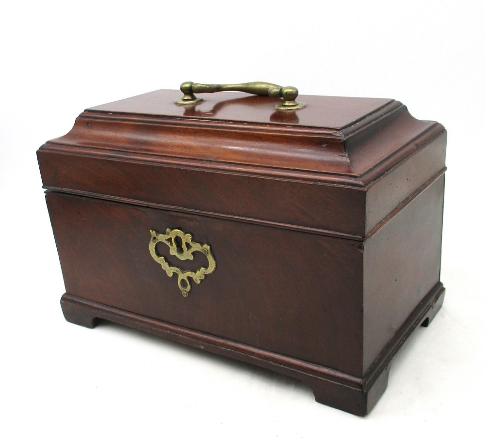 A rectangular George III mahogany tea caddy featuring a stepped hinged lid, a brass swan-neck handle, and a pierced brass keyhole escutcheon. View IV