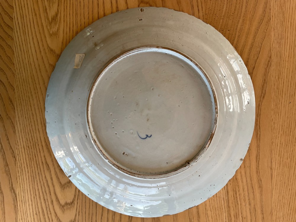 An antique circular Dutch Delft tin-glazed earthenware charger decorated with cobalt blue floral patterns and a central rosette motif against a white glaze. View II