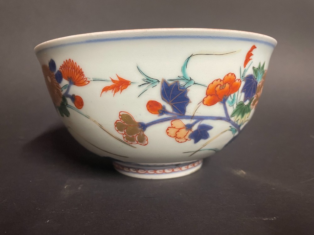 A circular Japanese Arita porcelain bowl seen from above, decorated with hand-painted underglaze blue and overglaze orange floral motifs. View III