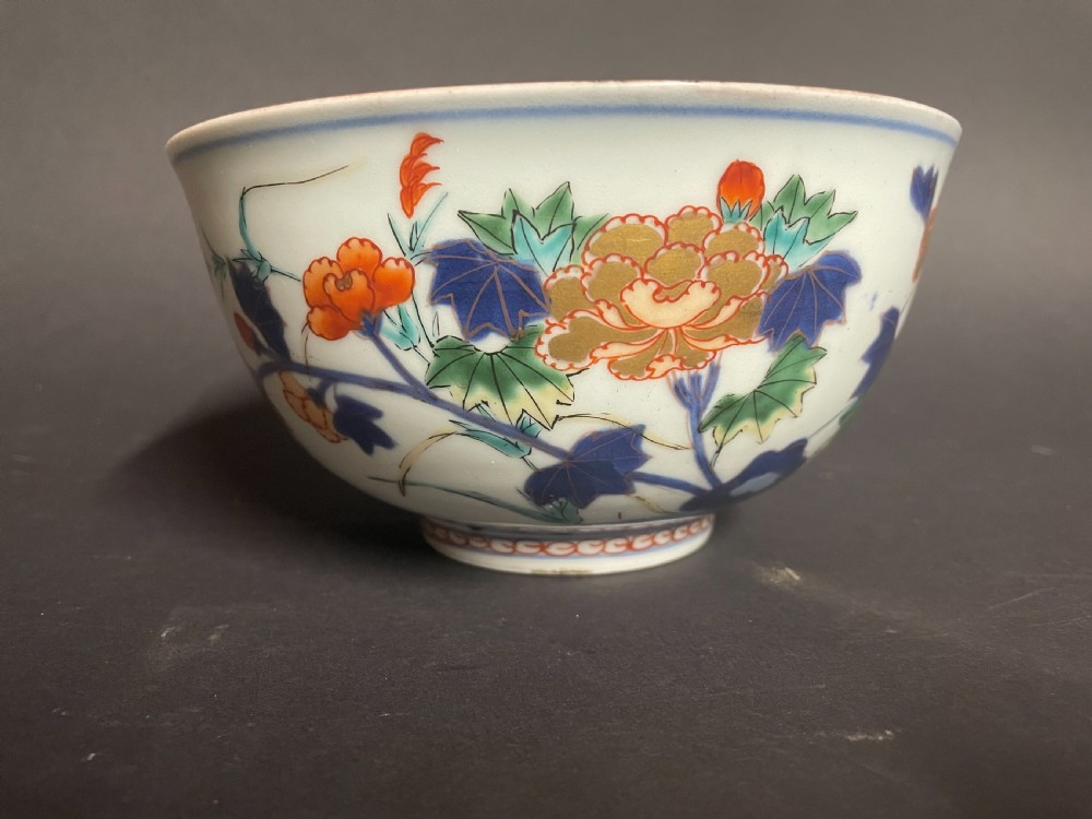 A circular Japanese Arita porcelain bowl seen from above, decorated with hand-painted underglaze blue and overglaze orange floral motifs. View IV