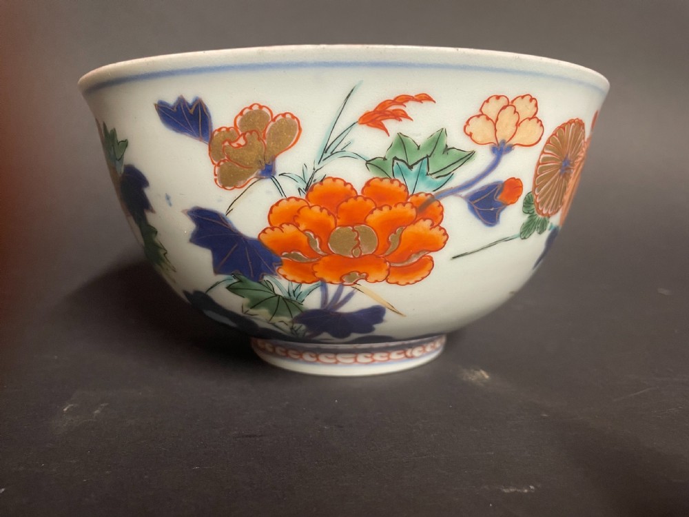 A circular Japanese Arita porcelain bowl seen from above, decorated with hand-painted underglaze blue and overglaze orange floral motifs. View VI