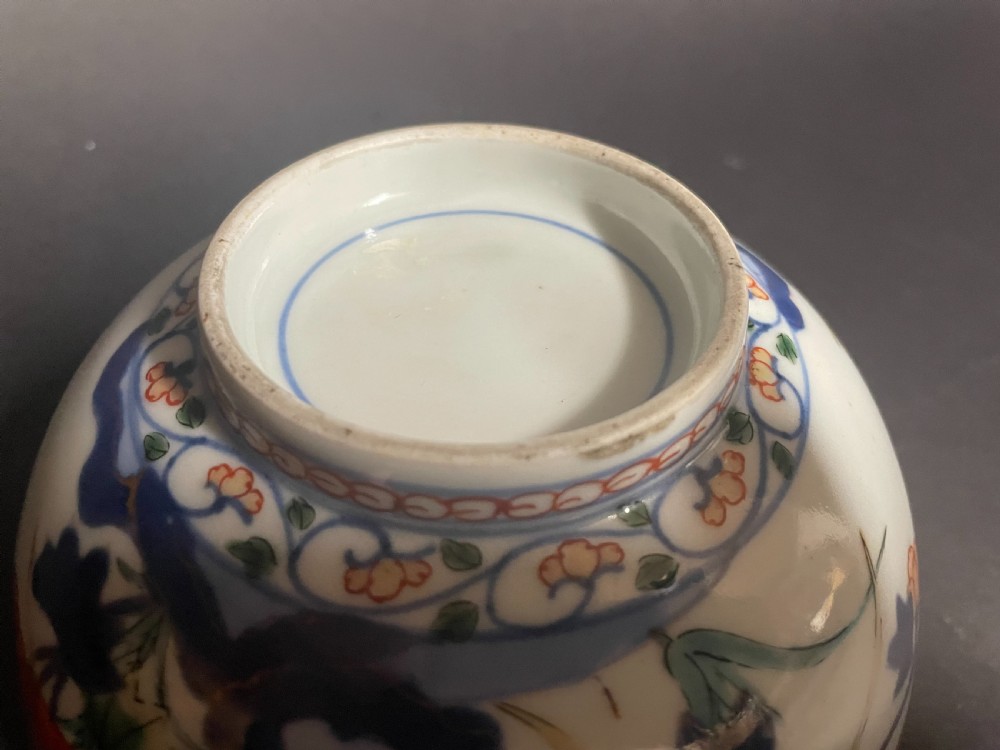 A circular Japanese Arita porcelain bowl seen from above, decorated with hand-painted underglaze blue and overglaze orange floral motifs. View VII