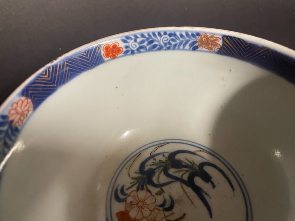A circular Japanese Arita porcelain bowl seen from above, decorated with hand-painted underglaze blue and overglaze orange floral motifs. View VIII
