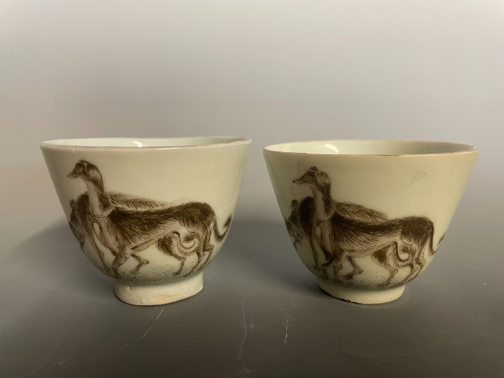 A pair of handleless Chinese export porcelain tea cups featuring hand-painted sepia greyhounds against an off-white ground. View II