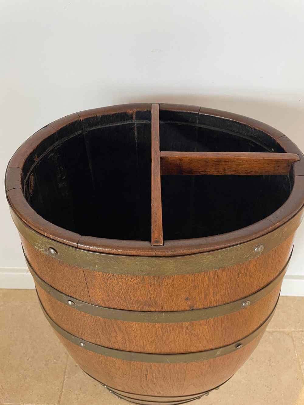 A barrel-shaped coopered oak umbrella stand featuring riveted metal bands and a central top divider. View II