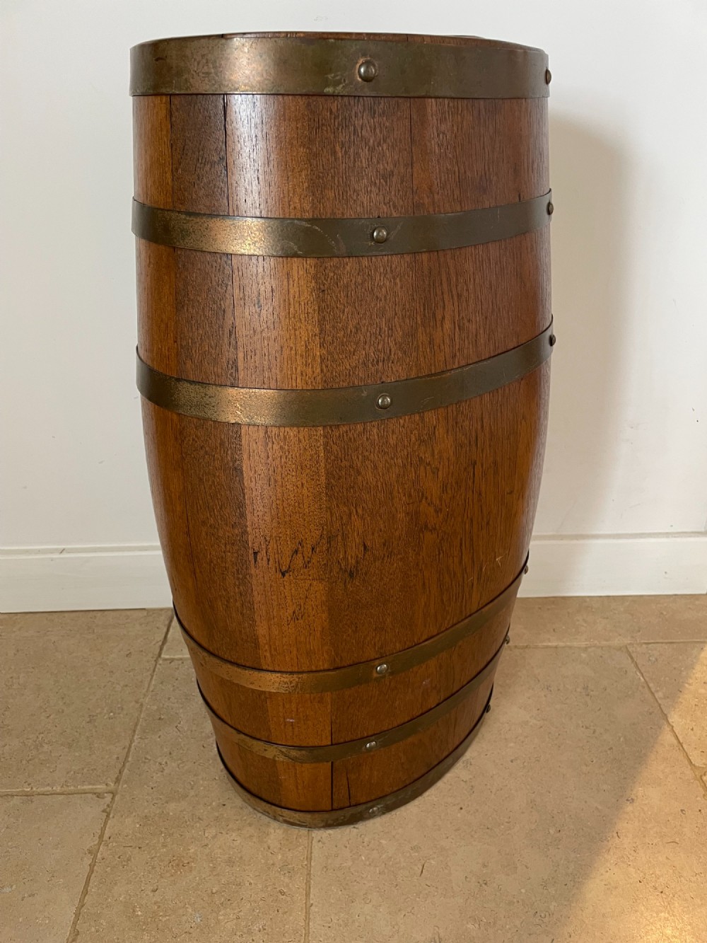 A barrel-shaped coopered oak umbrella stand featuring riveted metal bands and a central top divider. View III