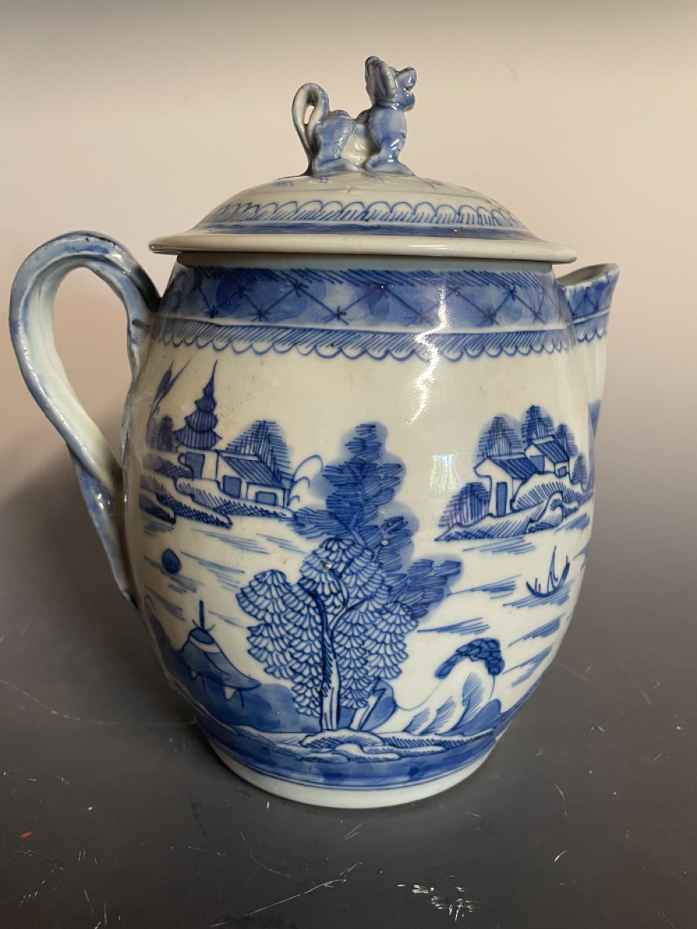 A blue and white Chinese export porcelain lidded jug featuring hand-painted pagoda landscape scenes and a foo dog lid finial. View III