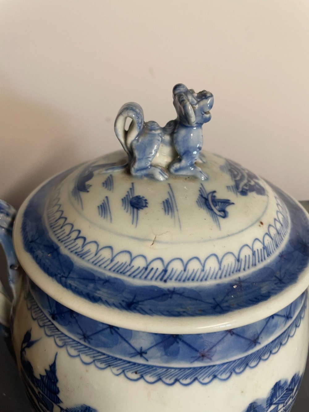 A blue and white Chinese export porcelain lidded jug featuring hand-painted pagoda landscape scenes and a foo dog lid finial. View IV