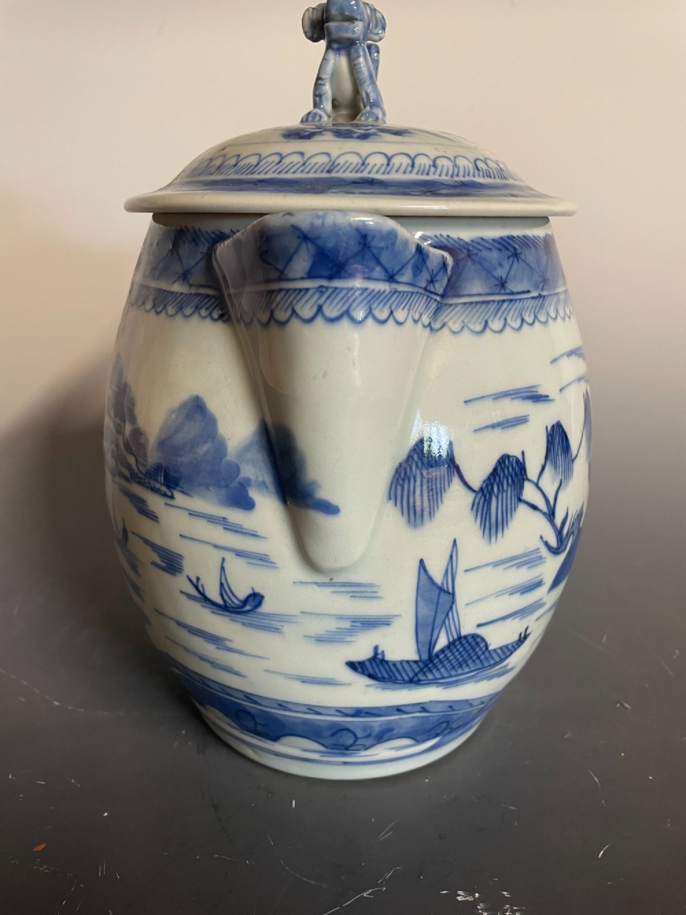 A blue and white Chinese export porcelain lidded jug featuring hand-painted pagoda landscape scenes and a foo dog lid finial. View V