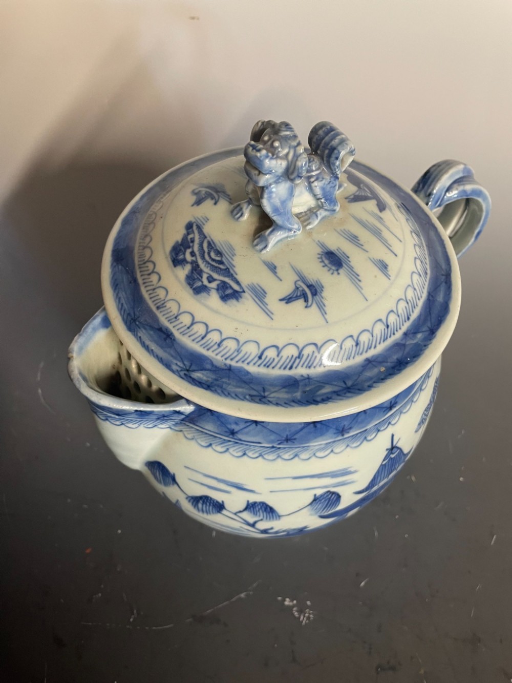 A blue and white Chinese export porcelain lidded jug featuring hand-painted pagoda landscape scenes and a foo dog lid finial. View VI