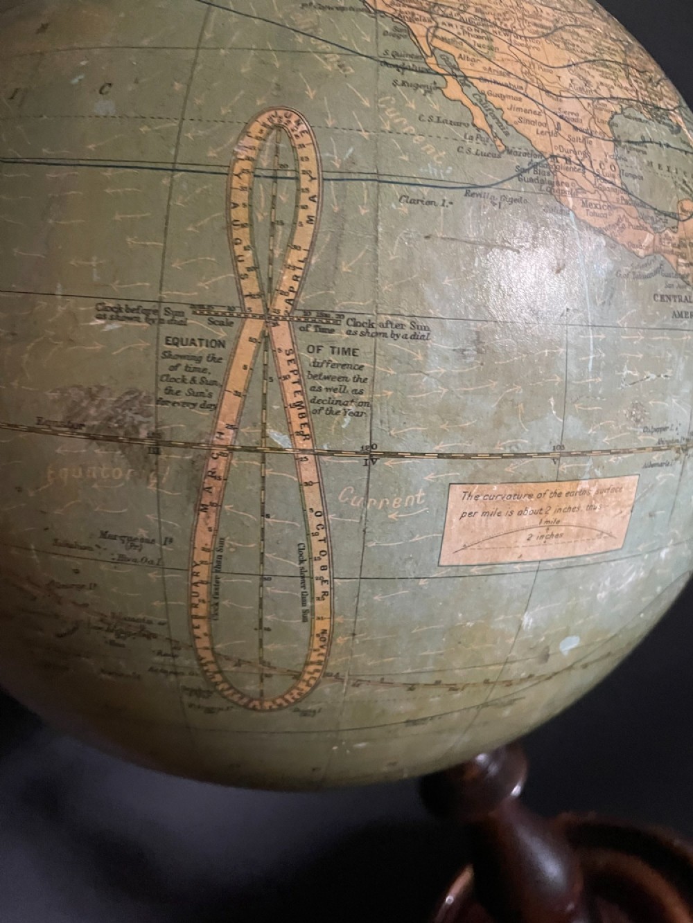 An antique terrestrial table globe mounted on a turned dark wood stand with a brass semi-meridian. View IV