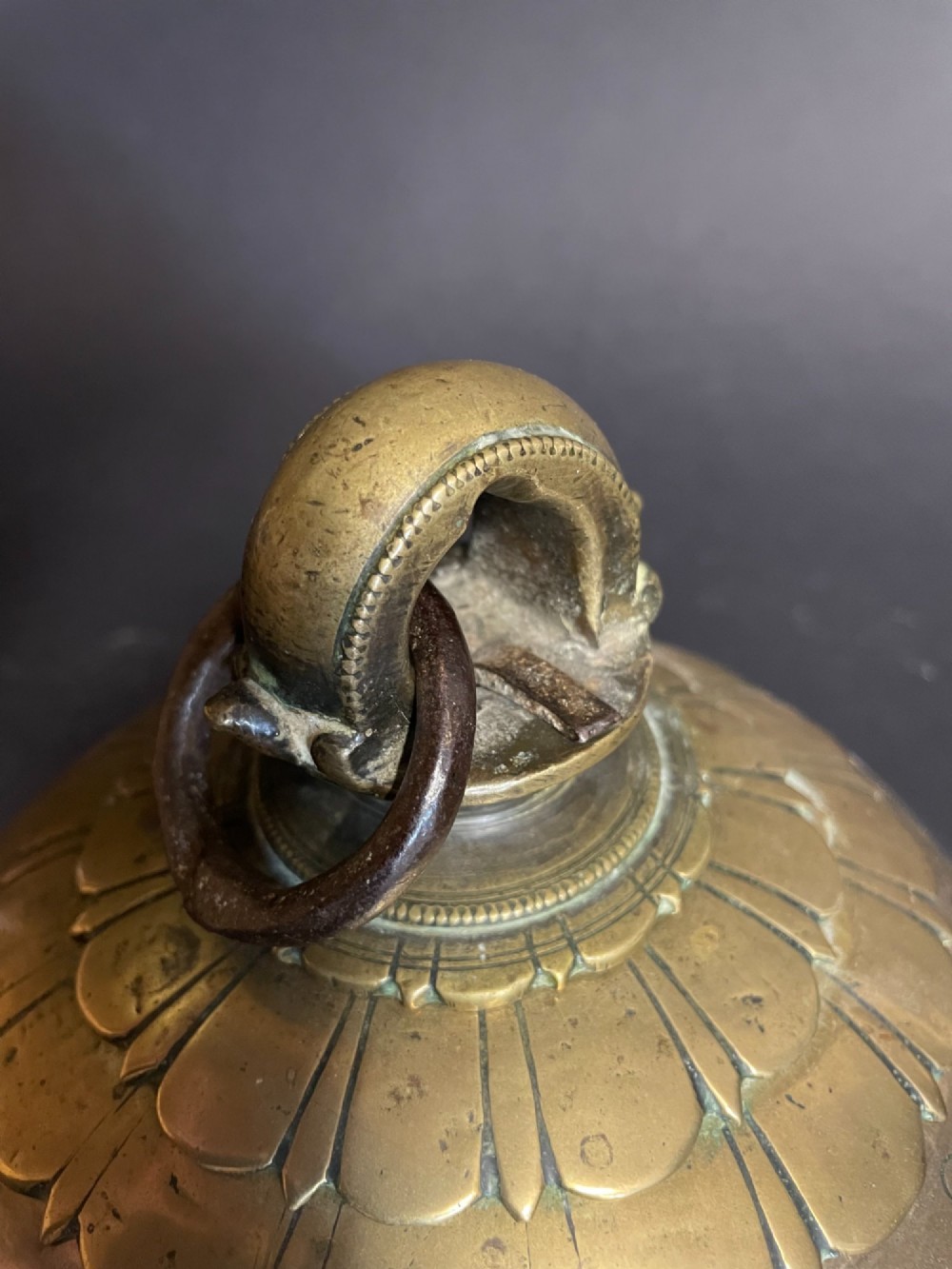 A dome-shaped Sino-Tibetan bronze bell featuring relief lotus petal decoration at the top collar and an iron attachment ring. View V