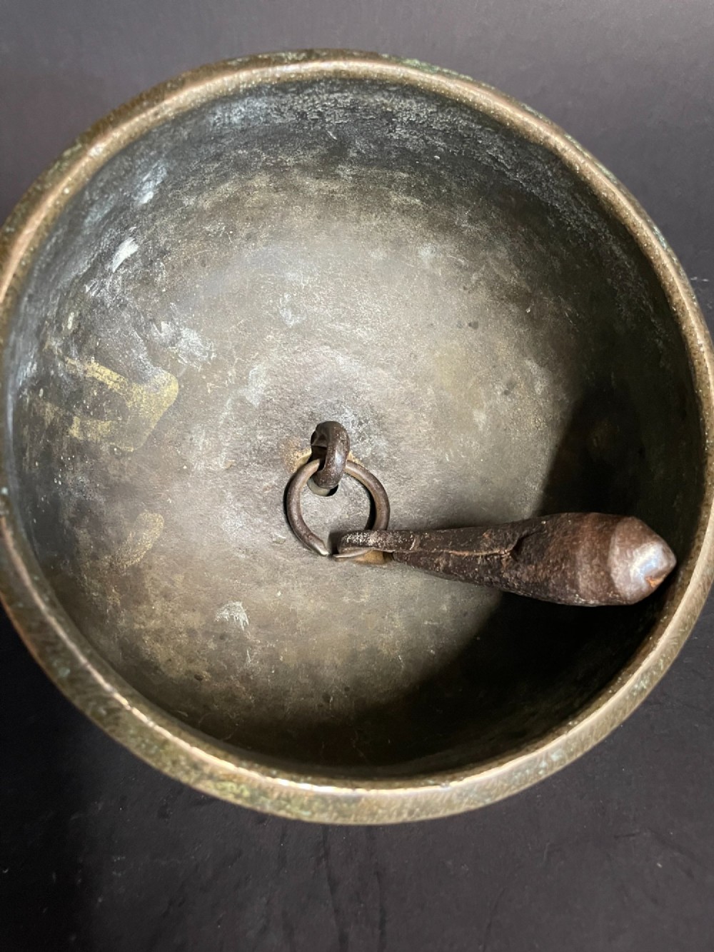 A dome-shaped Sino-Tibetan bronze bell featuring relief lotus petal decoration at the top collar and an iron attachment ring. View VI