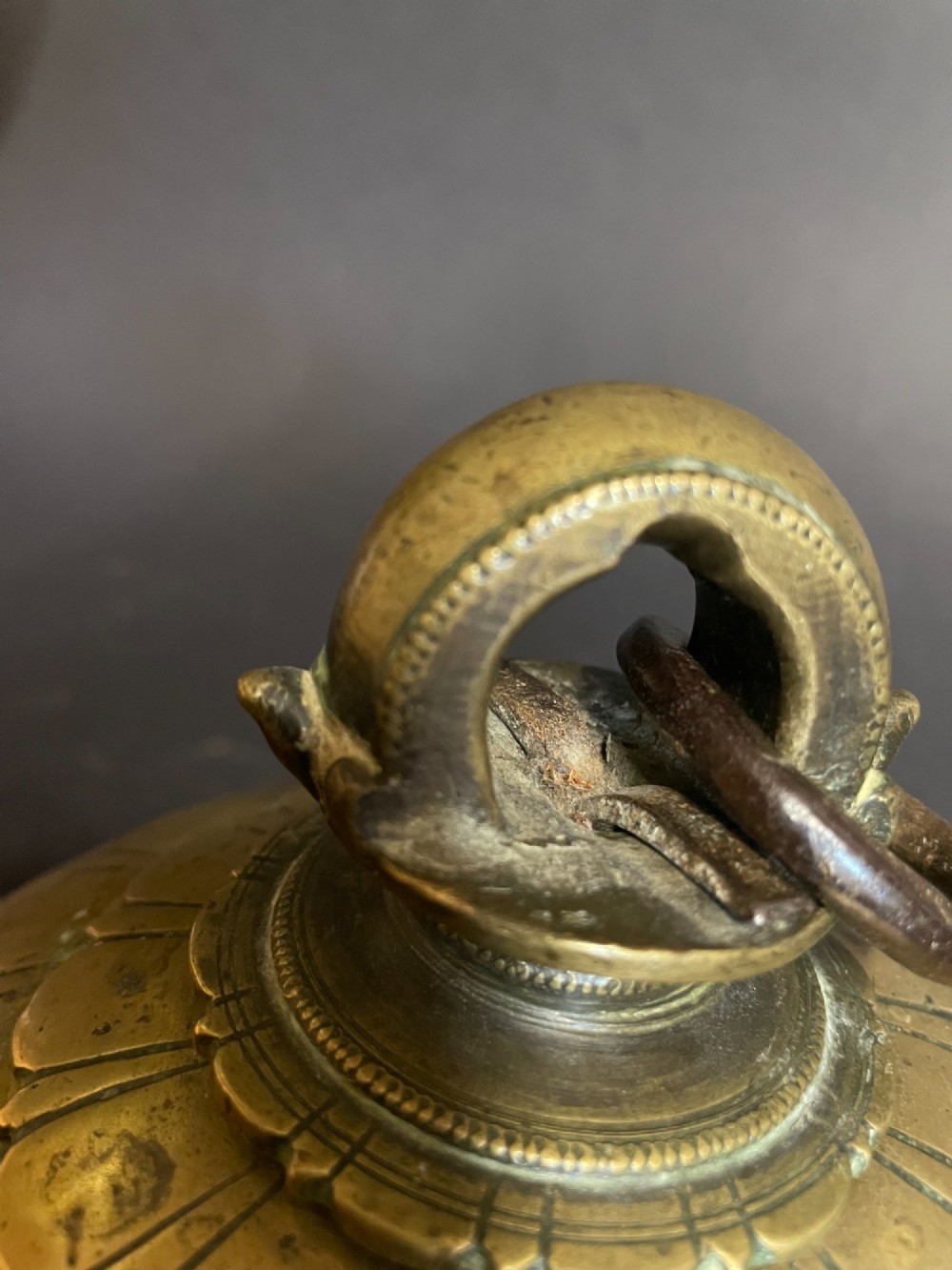 A dome-shaped Sino-Tibetan bronze bell featuring relief lotus petal decoration at the top collar and an iron attachment ring. View VIII