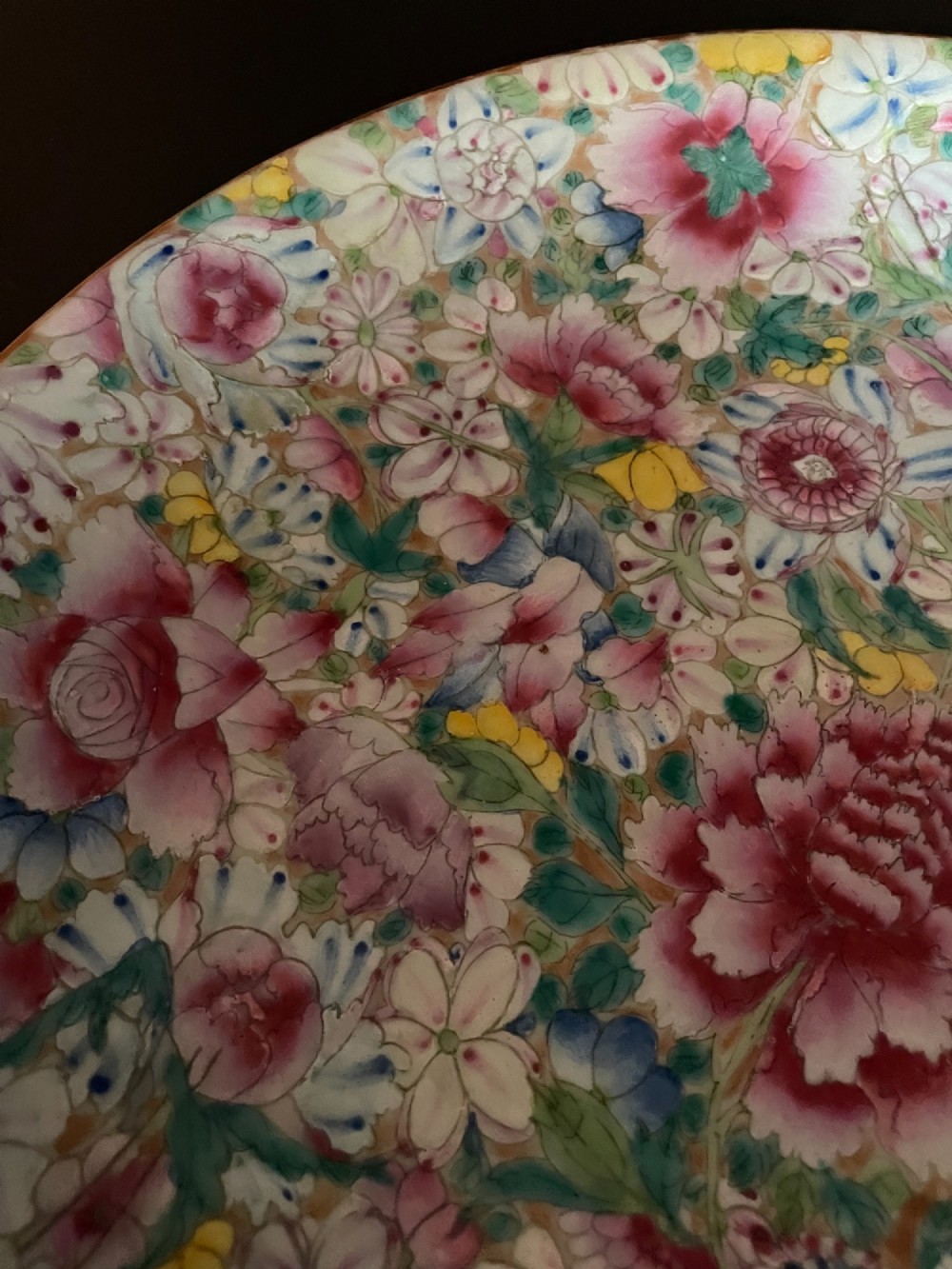 A pair of shallow circular Chinese porcelain dishes decorated with a dense all-over floral Millefleurs pattern in pink, green, yellow, and blue overglaze enamels. View III