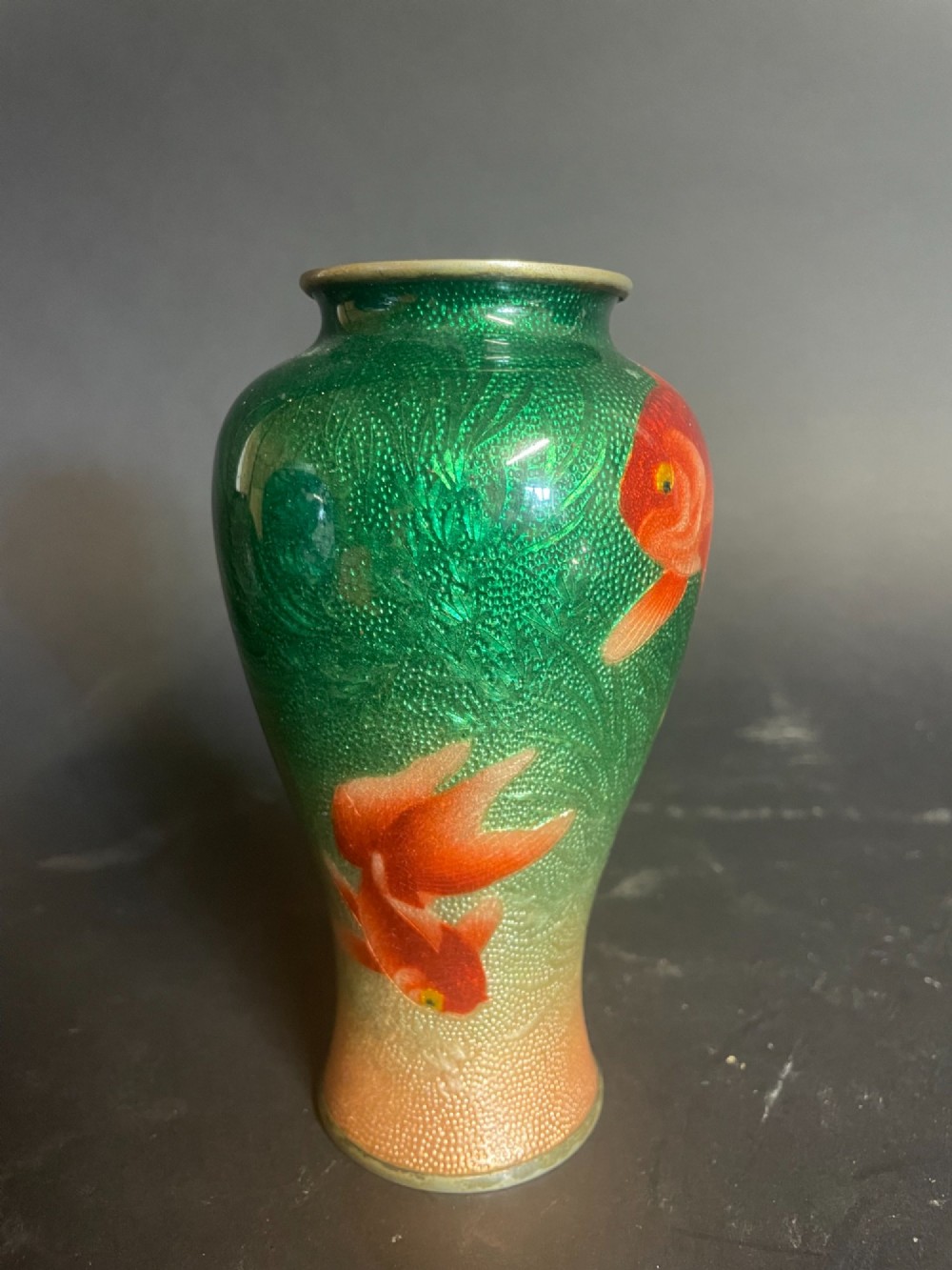 A baluster-shaped Japanese Gin-Bari cloisonne vase featuring swimming red and black goldfish against a translucent emerald green foil-backed enamel ground. View II
