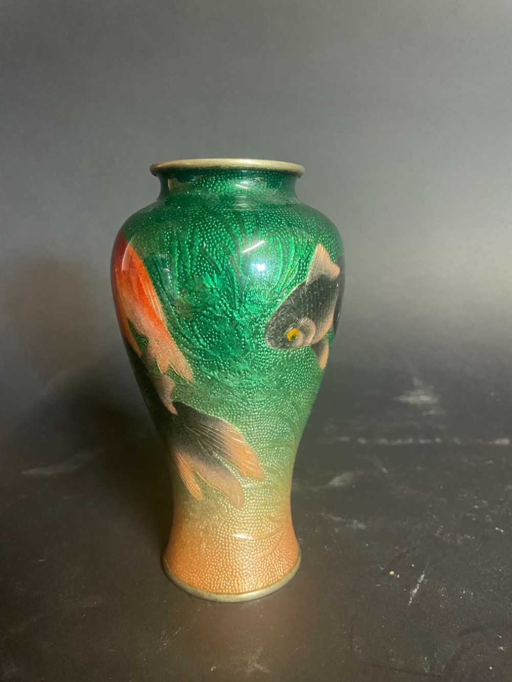 A baluster-shaped Japanese Gin-Bari cloisonne vase featuring swimming red and black goldfish against a translucent emerald green foil-backed enamel ground. View V