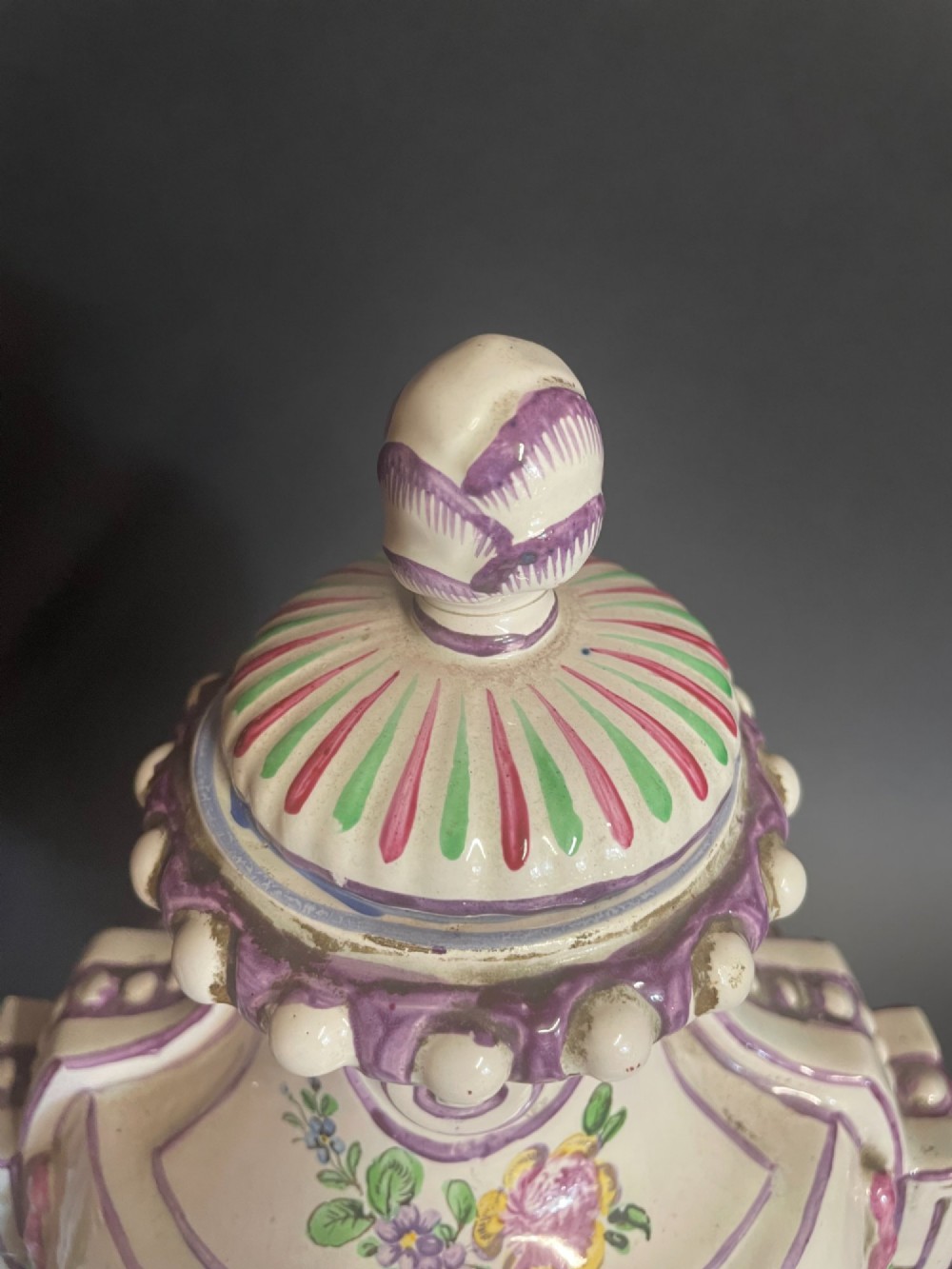 A pair of antique French Sceaux faience lidded urns decorated with hand-painted pastoral scenes, floral garlands, and moulding on square bases. View IX