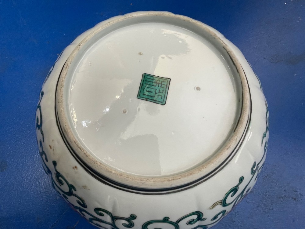 A fluted Japanese porcelain bowl with a scalloped edge, decorated with a central painted green dragon and ornate enamel borders. View V